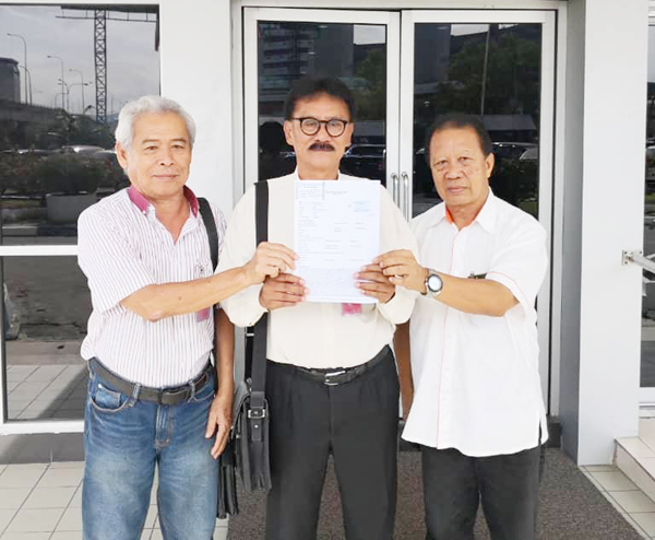 NORBERT (tengah) menunjukkan laporan polis yang dibuat di IPD Kota Kinabalu pada Khamis.