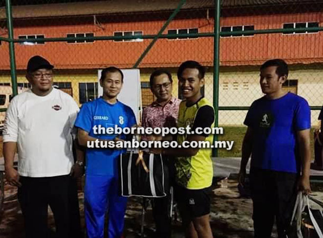  Zaini menyampaikan hadiah kepada wakil-wakil pasukan menyertai perlawanan Futsal Komrado Persahabatan Belia di Kuching.