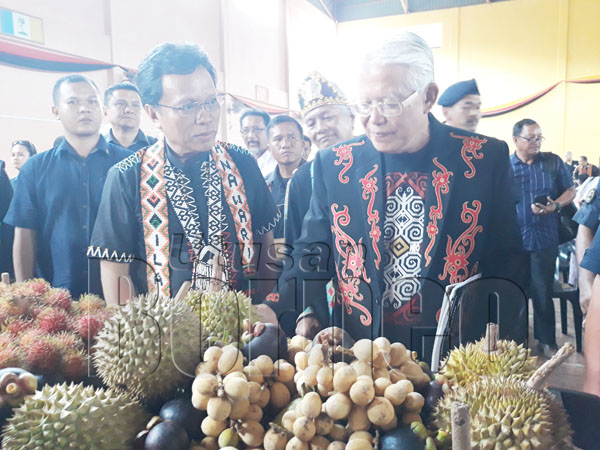 SHAFIE (kiri) bersama Richard (kanan) melawat pameran produk buah-buahan tempatan selepas merasmikan Sambutan Ilau Panawari.