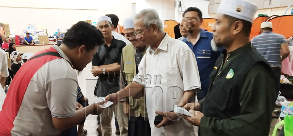 UDA (dua, kanan) menyampaikan sumbangan berupa wang poket dari MBR kepada salah seorang mangsa kebakaran di Kampung Pasir Putih.