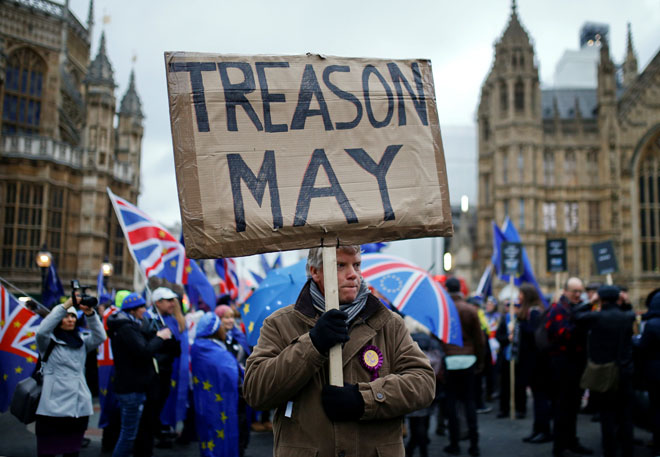  Seorang penunjuk perasaan pro-Brexit membawa poster manakala penunjuk perasaan anti-Brexit berdemonstrasi                        di luar Dewan Parlimen di London, Britain, pada Selasa. — Gambar Reuters