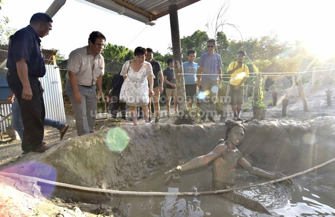  Jepinus (dua kiri) mendengar penerangan daripada Angel (tiga kiri) mengenai kebaikan mandi lumpur gunung berapi di KP Mud.