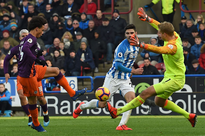  Sane (kri) berjaya memperdaya Lossl (kanan) sebelum menjaringkan gol ketiga City pada perlawanan Liga Perdana Inggeris menentang Huddersfield di Stadium John Smith, Huddersfield pada Ahad lepas. — Gambar AFP
