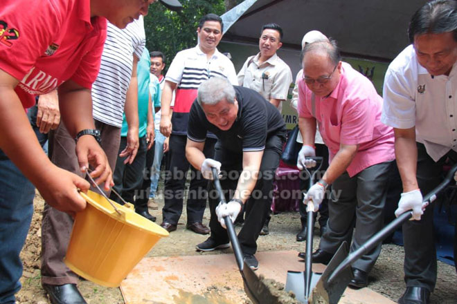  (Dari tiga kanan) Awang Tengah, Henry, Dr Abdul Rahman, Awangku Jinal (berdiri kiri) melakukan gotong-royong membina rumah seorang penduduk di Merapok kelmarin.