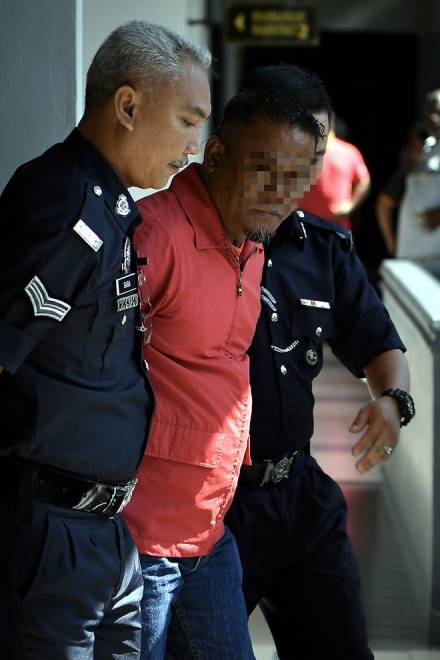  Kamarul diiring keluar oleh dua anggota polis selepas mengaku tidak bersalah di Mahkamah Majistret, Melaka, semalam. — Gambar Bernama