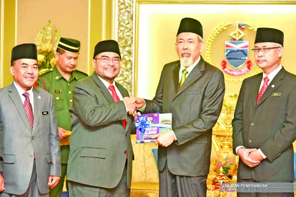 MUJAHID menyampaikan cenderahati kepada Juhar (dua dari kanan) sambil diperhatikan oleh Paimuzi (dua dari kiri) dan Norjeli.