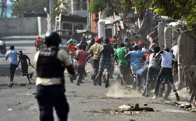  Penunjuk perasaan lari apabila polis Haiti melepaskan tembakan sewaktu                         pertelingkahan di Port-au-Prince pada Rabu lepas. — Gambar AFP