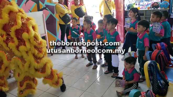  Aksi lincah penari tarian singa menarik perhatian kanak-kanak.