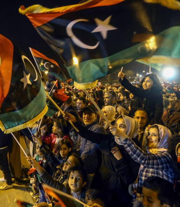  Rakyat Libya mengibarkan bendera kebangsaan ketika menyertai perhimpunan untuk menandakan ulang tahun ke-8 pemberontakan di Martyrs Square di Tripoli pada Ahad. — Gambar AFP