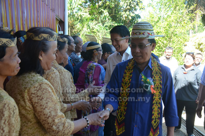  Penatai Dr Rundi (mua) enggau Dennis (kiba iya) dilalu peranak Long Nakan lebuh seduai ngulu pengawa bejadi nyerahka projek SARES. 