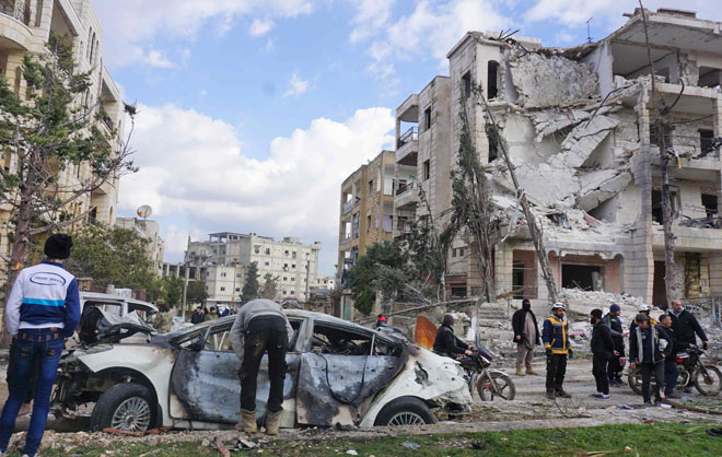  Orang ramai melihat keadaan di tempat kejadian susulan letupan bom kereta dan motosikal di Idlib, kelmarin. — Gambar AFP