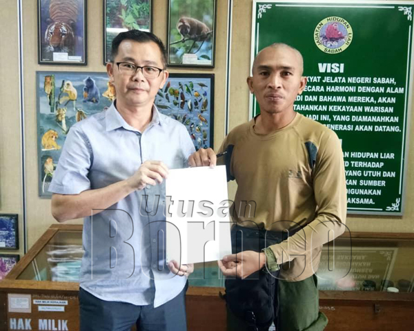 CHUNG menyerahkan surat aduan penduduk kepada pegawai JHL Cawangan Tawau.