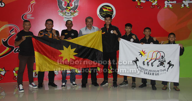  Ahmad Rodzli (empat kiri) bersama Ali (tiga kiri), jurulatih dan petinju semasa majlis penyerahan bendera di lobi Stadium Sarawak, Petra Jaya semalam.