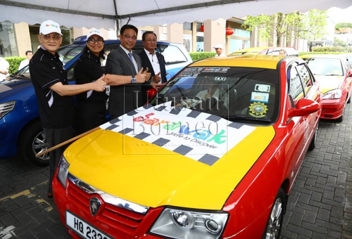 Abdul Karim (dua kanan) bersama Sharzede (dua kiri) dan Abdul Wahab (kiri) selepas menyempurnakan pelancaran pelekat kereta Kempen Melawat Sarawak di perhentian teksi, Plaza Merdeka di sini hari ini.