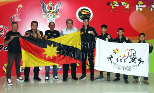 Ahmad Rodzli (empat kiri) bersama Ali (tiga kiri), jurulatih dan petinju semasa majlis penyerahan bendera di lobi Stadium Sarawak, Petra Jaya hari ini.