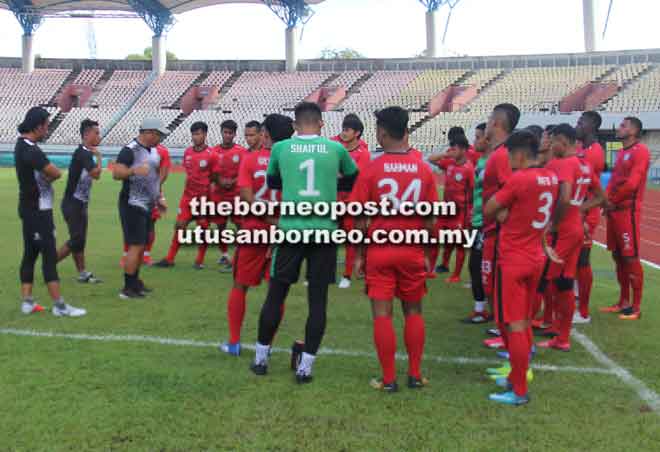  Mohd Farhan (tiga kiri) memberi taklimat kepada pemain-pemain sebelum memulakan sesi latihan di Stadium Negeri, Kuching semalam.