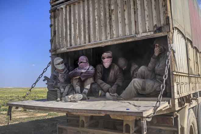  Gambar yang diambil pada 20 Februari lepas menunjukkan sebuah trak yang membawa kaum lelaki, yang dikenali sebagai pejuang kumpulan Daesh yang menyerah diri kepada Angkatan Demokratik Syria (SDF) pimpinan Kurdish, ketika mereka dibawa keluar dari kubu terakhir Daesh  di Baghouz dalam wilayah Deir al-Zour, utara Syria. — Gambar AFP