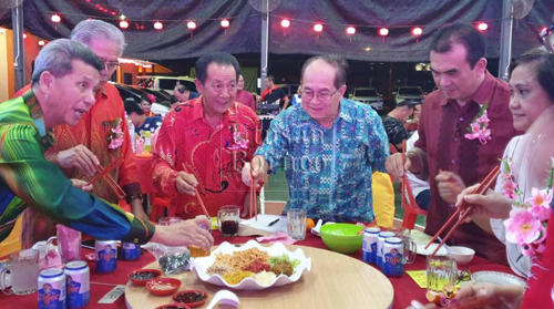 Uggah bersama isterinya, Doreen, Robert dan Penghulu Goh Leng Tong menggaul Yee Sang pada majlis Jamuan Tahun Baharu Cina di Spaoh pada Jumaat 