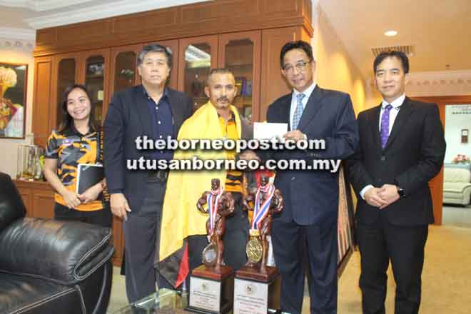  Abdul Karim menyerahkan cek insentif kepada Buda sambil disaksikan (dari kanan) Hii, Ong dan Villaivan di Kuching kelmarin. 