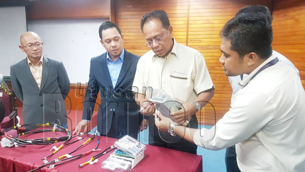 SHAFIE (tiga kiri) menunjukkan teknik usikan meter elektrik oleh pelaku sambil mempamerkan kesemua alat rampasan yang lain. Turut kelihatan Norhizami (dua kiri).