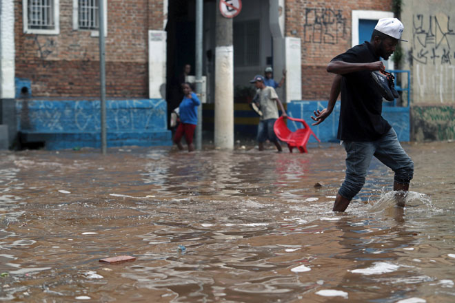  Penduduk menempuh jalan raya yang ditenggelami air selepas hujan lebat dalam kawasan kejiranan Vila Prudente di Sao Paulo, Brazil pada Isnin. — Gambar Reuters