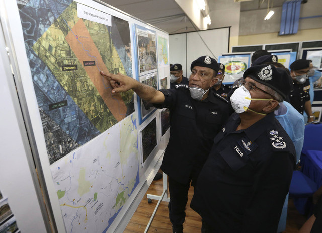 Mohamad Fuzi (kanan) melihat peta lokasi pencemaran Sungai Kim Kim yang ditunjukkan oleh Ketua Polis Johor Datuk Mohd Khalil Kader Mohd hari ini - Gambar Bernama 
