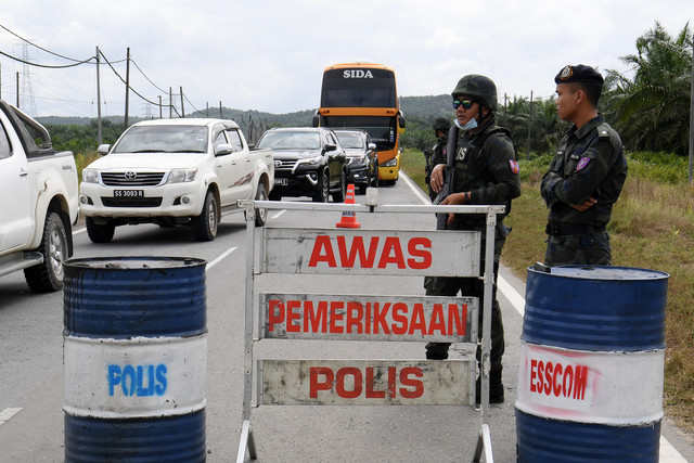  Anggota ESSCom melakukan kawalan dan pemeriksaan terhadap pengguna jalan raya di RCP Sapi Nangoh hari ini. - Gambar Bernama 