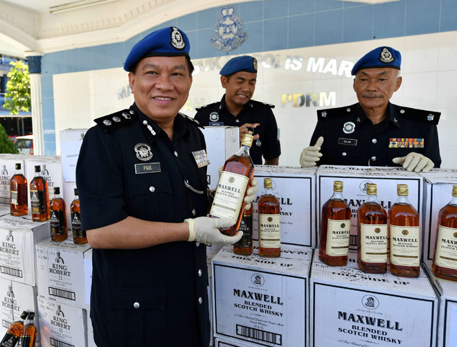  Paul (kiri) menunjukkan minuman keras tidak bercukai kastam yang dirampas dengan penahanan sebuah pancuan empat roda di Taman Pulai Bayu semalam pada sidang media di Markas Pasukan Polis Marin Wilayah 2 dekat Johor Bahru, semalam. — Gambar Bernama