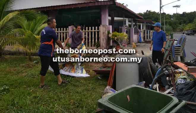  Awangku Wahab (kiri) dan penduduk Taman Seri Patiambun mengangkat sampah yang berjaya dikumpul.