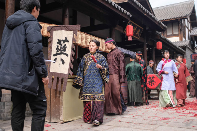  Gambar yang diambil pada 30 Januari 2019 ini menunjukkan beberapa pelakon tambahan memakai kostum zaman silam berjalan di set penggambaran untuk sebuah drama TV China di Hengdian World Studios. — Gambar Reuters