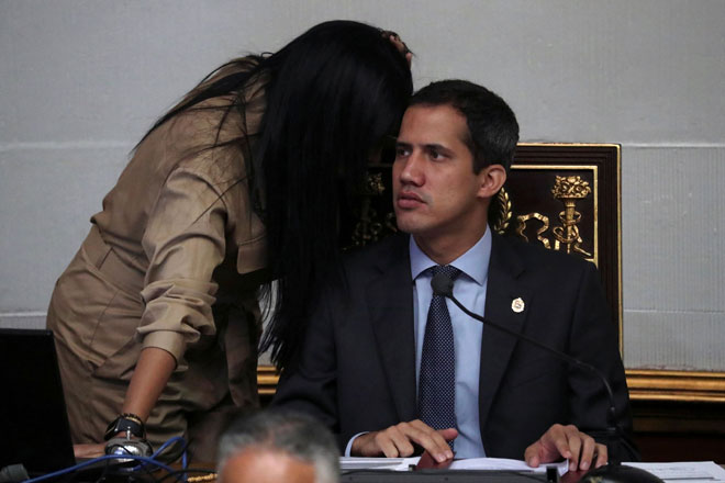  Seorang kakitangan membisikkan maklumat kepada Guaido (kanan) ketika sesi Perhimpunan Kebangsaan di Caracas, Venezuela pada Selasa. — Gambar Reuters