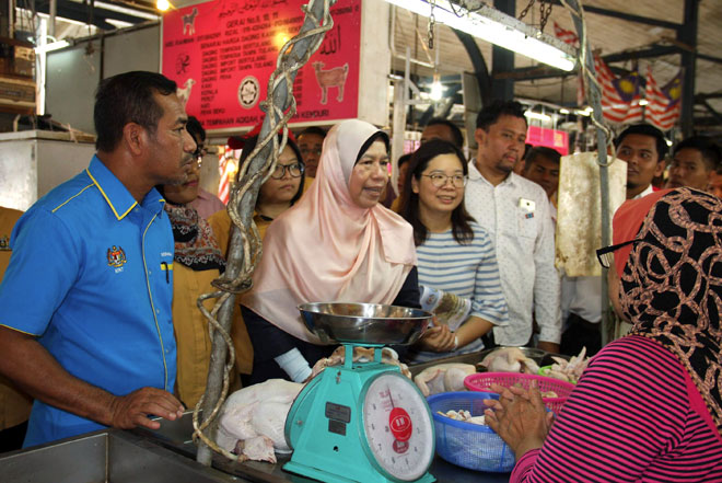  Zuraida (dua kiri) bertanyakan sesuatu dengan seorang peniaga ayam ketika melakukan lawatan kerja di Pasar Taiping dekat Taiping, semalam. — Gambar Bernama