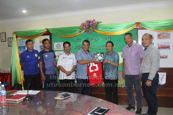  Posa (tiga kanan) melakukan penyerahan jersi dan bola tajaan FAS kepada Edward sambil disaksikan yang lain di SSTJ semalam.