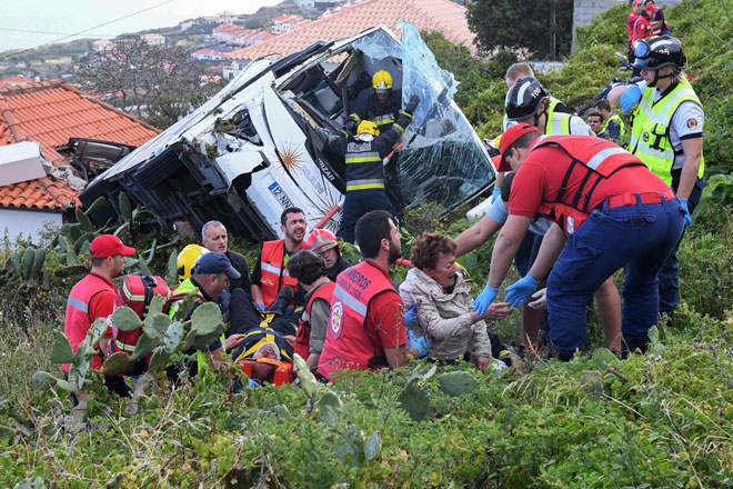  Anggota bomba membantu mangsa bas pelancongan yang mengalami kemalangan pada Rabu di Caniço, di Pulau Madeira, Portugal. — Gambar AFP