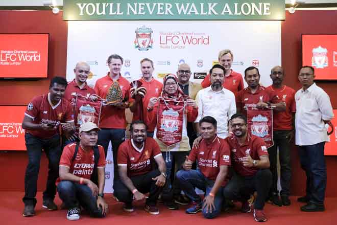  Hyypia (berdiri empat kanan), Jason McAteer (berdiri empat kiri) dan Steve McManaman (berdiri tiga kiri) bergambar dengan penyokong Liverpool FC ketika hadir sempena jelajah LFC World di Pusat Beli-Belah One Utama, semalam. — Gambar Bernama