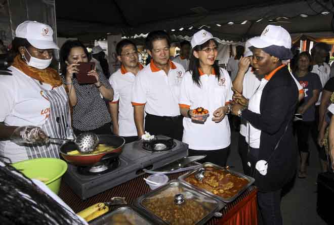  Teresa Kok (dua kanan) mendengar penerangan dari wakil peserta dari Ghana Neematu Ziblim Adam (kanan) tentang penggunaan minyak sawit dalam masakan ketika mengadakan lawatan ke gerai masakan pada Program Pertandingan Memasak Menggunakan Minyak Sawit Bersempena Kempen Sayangi Sawitku, semalam. — Gambar Bernama