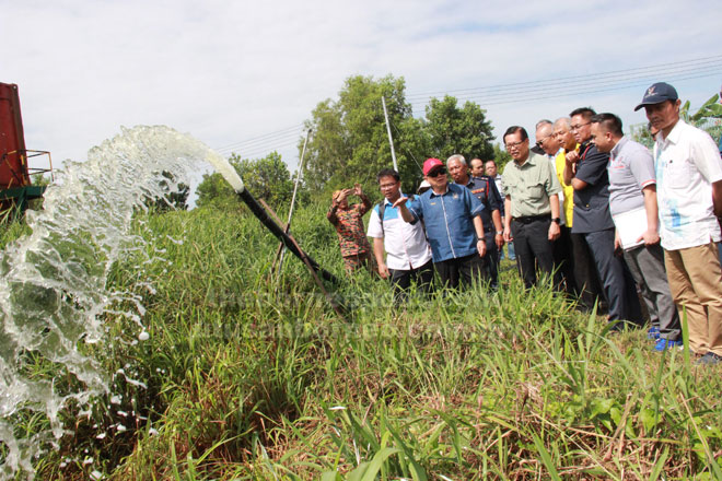  Uggah (tiga kiri) menyaksikan pengairan kawasan tanah gambut menggunakan sumber air dari telaga tiub Tudan semasa mengadakan lawatan ke Menara Tinjau di Tudan, Miri semalam. 
