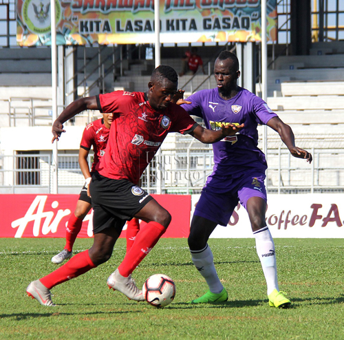 Penyerang Sarawak, Hudson Dias cuba melakukan percubaan sambil diasak pertahanan UiTM FC, Bernard Coulibally pada aksi Liga Premier di Stadium Negeri, Petra Jaya hari ini.