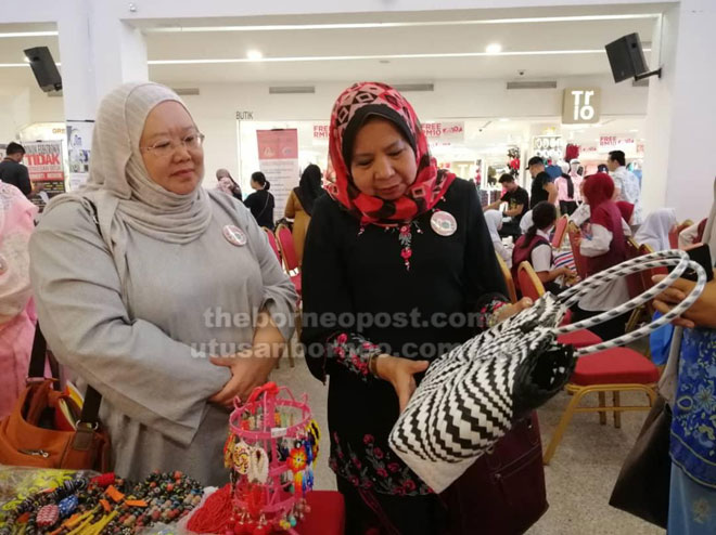  Arpah (kiri) dan Rosey melihat pameran kraf yang diadakan semasa pelancaran tersebut di sebuah pusat beli-belah di Miri semalam.