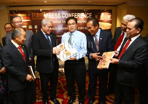 Awang Tengah (lima kanan) menerima buku 'Glossary of Classification Timber & Timber Products Of Sarawak' daripada Bong sambil disaksikan yang lain.- Gambar Muhammad Rais Sanusi