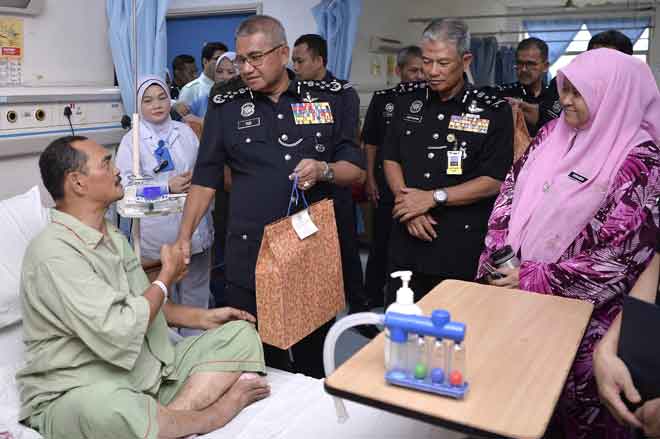  Mohamad Fuzi menyampaikan sumbangan kepada anggota Polis Diraja Malaysia (PDRM) Sub Inspektor Ghazali Md Din yang telah selamat menjalani pembedahan hempedu ketika membuat lawatan ke Hospital Selayang sempena Peringatan Hari Polis Ke-212 di Kuala Lumpur, semalam. — Gambar Bernama