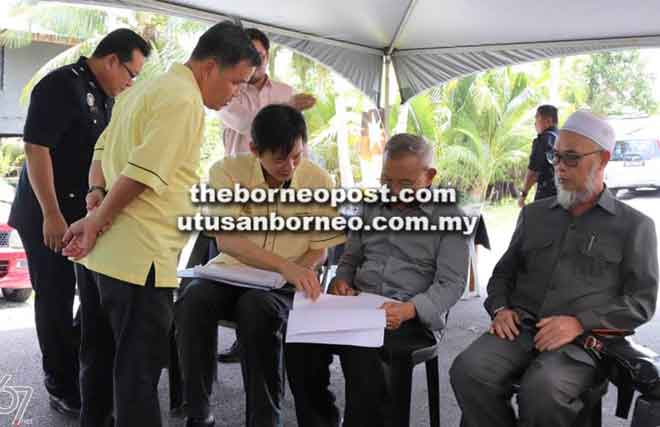  Talib (dua kanan) mendengar penerangan daripada Lau Pit Hwa (kiri) mengenai projek yang telah dilaksanakan di Kuala Tatau.