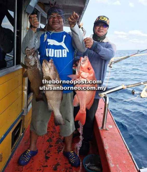  Peserta memancing menunjukkan ikan kerapu dan merah yang berjaya ditangkap.