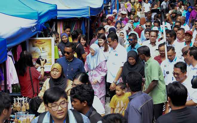  Wan Azizah yang juga Pengerusi Majlis Penasihat Parti Keadilan Rakyat (PKR) beramah mesra dengan peniaga dan pengunjung sempena lawatan mesra ke Pasar Tamu Mingguan di Sandakan, semalam. — Gambar Bernama