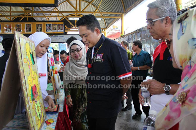  Pelajar sedang menerangkan PBL yang diciptanya kepada tetamu kehormat.