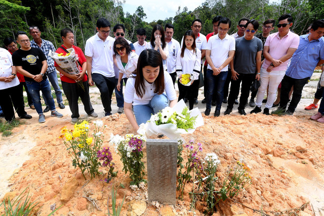 Vivian meletakkan jambangan bunga di kubur mendiang bapanya Stephen Wong Tien Fatt di Tanah Perkuburan Kristian Sandakan hari ini. - Gambar Bernama 