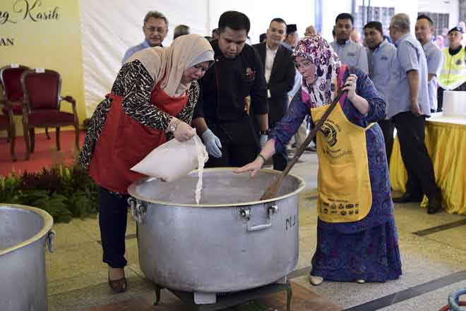  Tunku Azizah Aminah Maimunah (kanan) dibantu Menteri Pembangunan Luar Bandar Datuk Seri Rina Mohd Harun ketika menyediakan bubur lambuk resipi istimewa baginda pada Program Bubur Lambuk Perdana Masjid-Masjid di Wilayah Persekutuan anjuran Jabatan Agama Islam Wilayah Persekutuan (JAWI) di Masjid Jamek Kampung Baru dekat Kuala Lumpur, semalam. — Gambar Bernama