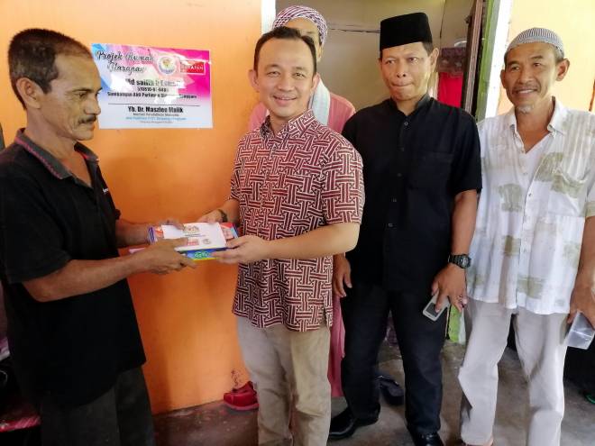 Maszlee menyampaikan kunci rumah dan wang saku kepada penerima bantuan Program Rumah Harapan Md Sallih Esmail di Kampung Parit Haji Hashim. - Gambar BERNAMA.