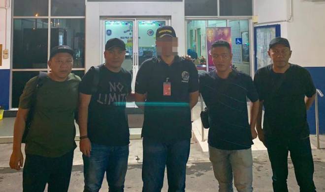 Sepasukan polis JSJ Lawas mengambil suspek (tengah) di Balai Polis Karamunsing Kota Kinabalu kira-kira jam 7.30 malam pada Sabtu.