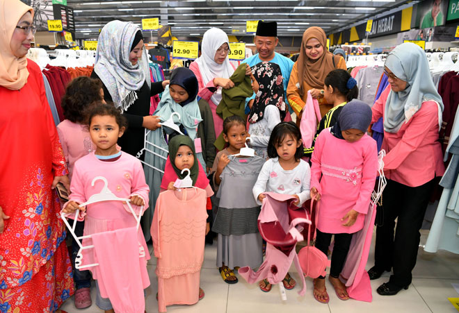  Dr Nila Armila (tiga, kiri), bersama Najwah Halimah (dua, kiri) dan Zainal (tiga, kanan) memakaikan pakaian kepada anak-anak asnaf pada Program Bantuan Raya Anak-Anak Asnaf Parlimen Pulai di Mydin Mall Mutiara Rini semalam. — Gambar Bernama